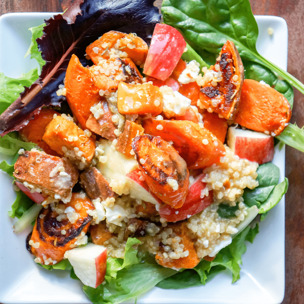 Bowl of roasted vegetable salad with feta and quinoa ready to eat.