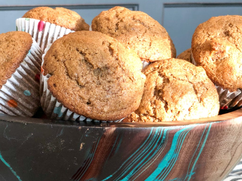 Banana Bread muffins piled in a pretty wooden bowl. 