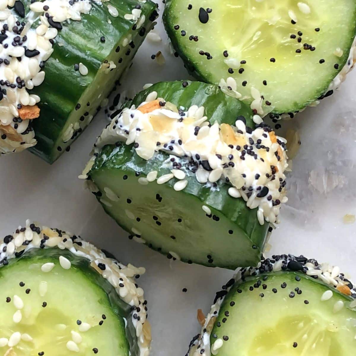 5 everything bagel cucumber bites on a white plate