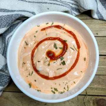 Sriracha Aioli in a white bowl on a wooden board