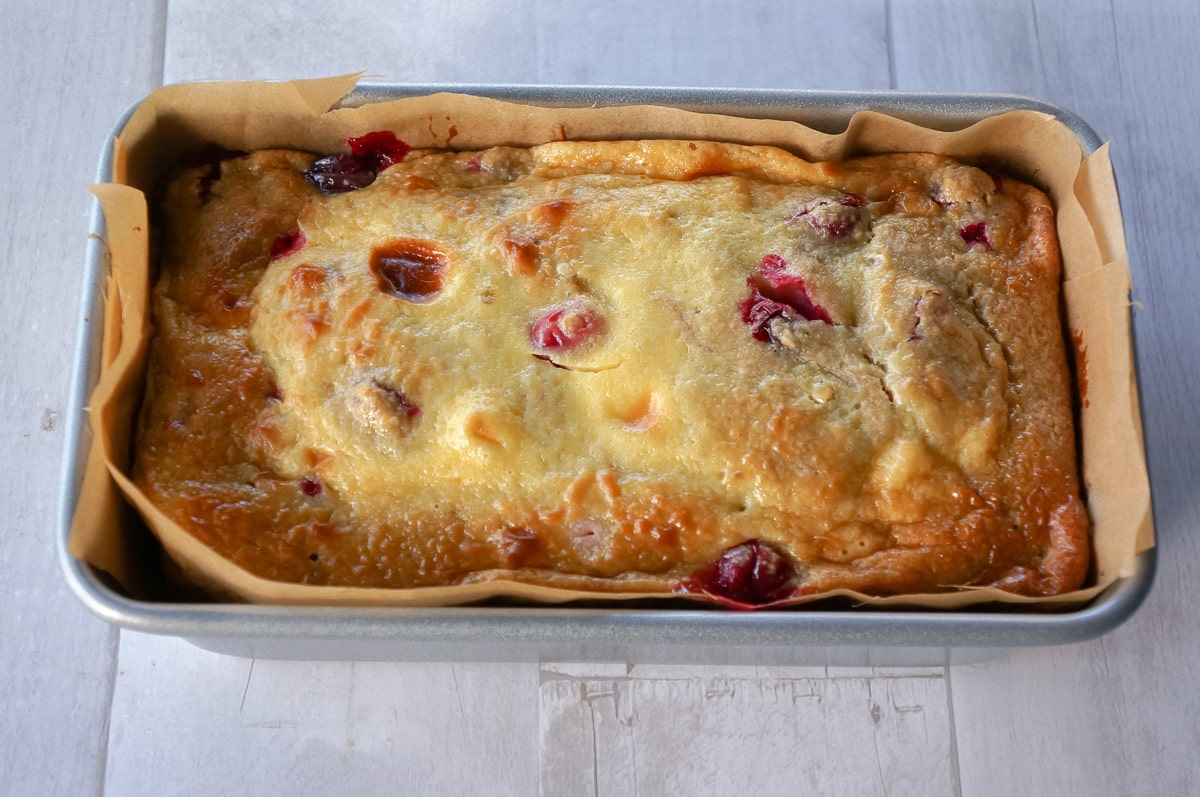 Cranberry orange oat flour bread in a loaf pan.