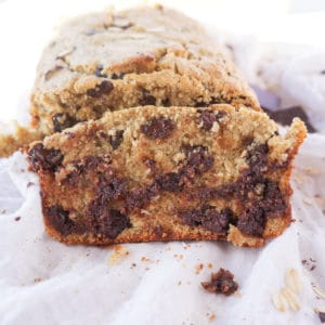 A slice of oatmeal banana bread with loads of melted dark chocolate.