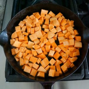 cubbed sweet potatoes in a cast iron skillet.