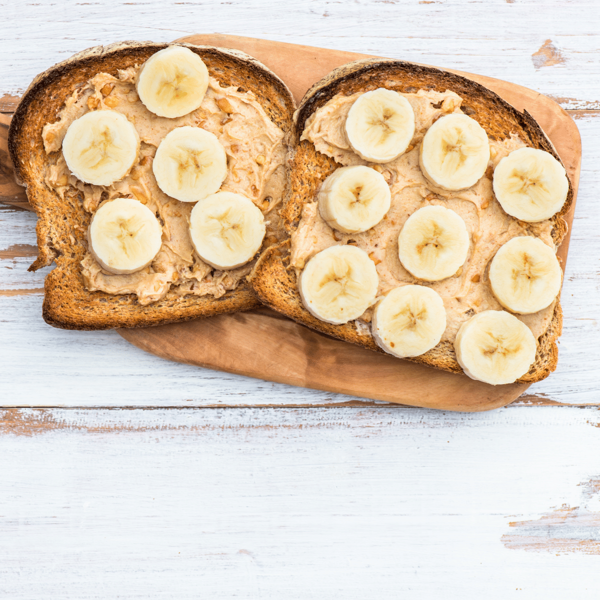 Whole grain peanut butter banana toast on a wooden board