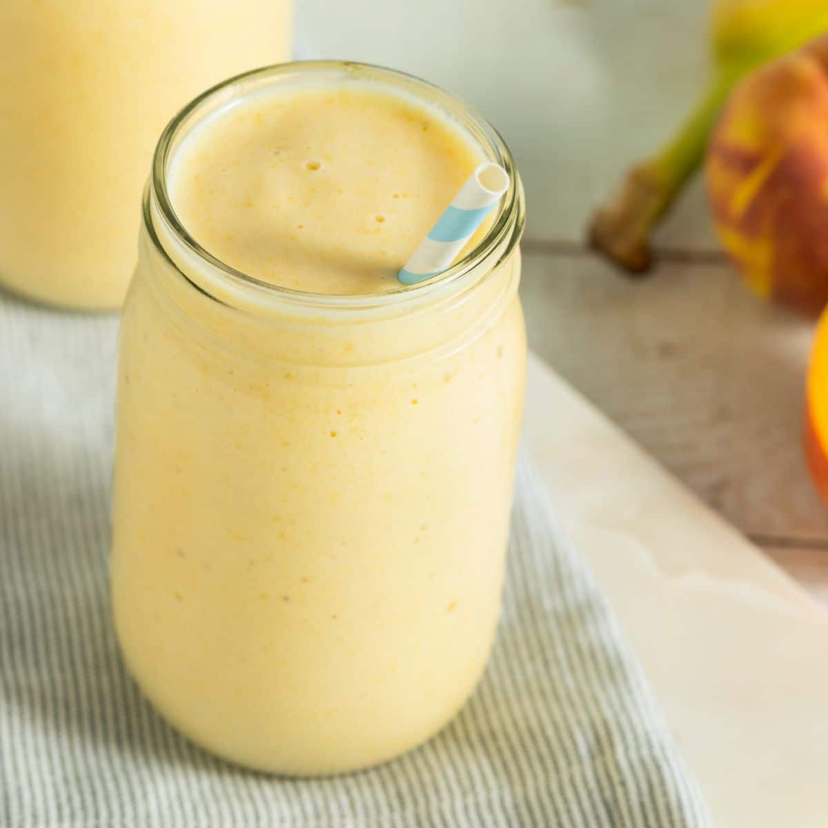 Pineapple peach smoothie in a glass cup